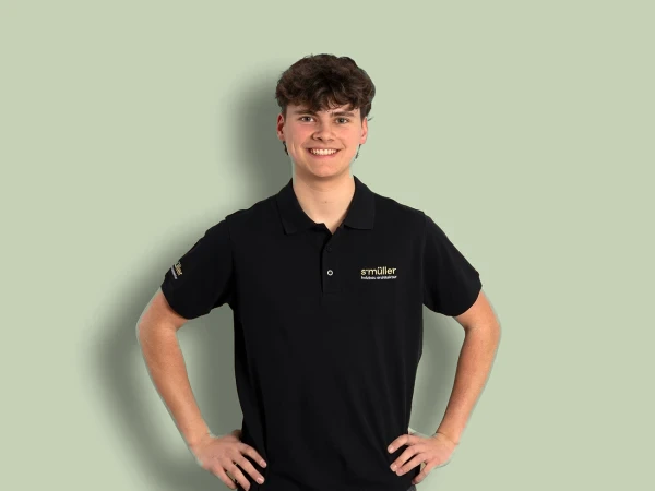 Levin Wild im schwarzen Poloshirt, lächelnd, die Hände in die Hüften gestützt