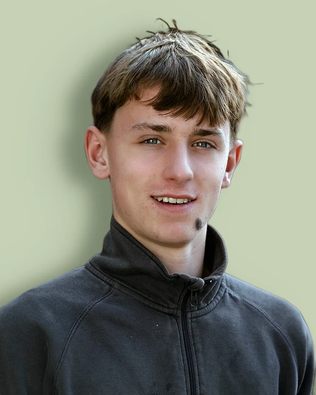 Luis Ledergerber im grauen Pullover, lächelnd